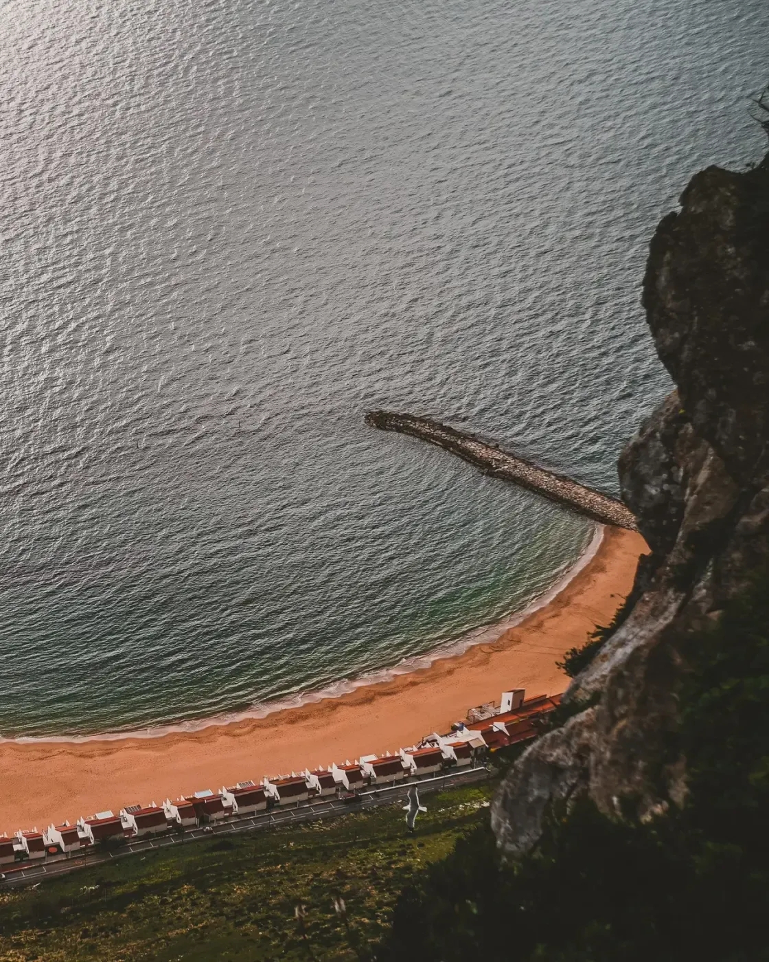 A curved beach and breakwater seen from high on the Rock of Gibraltar